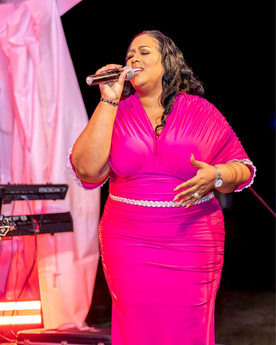 Queen B singing in pink on stage