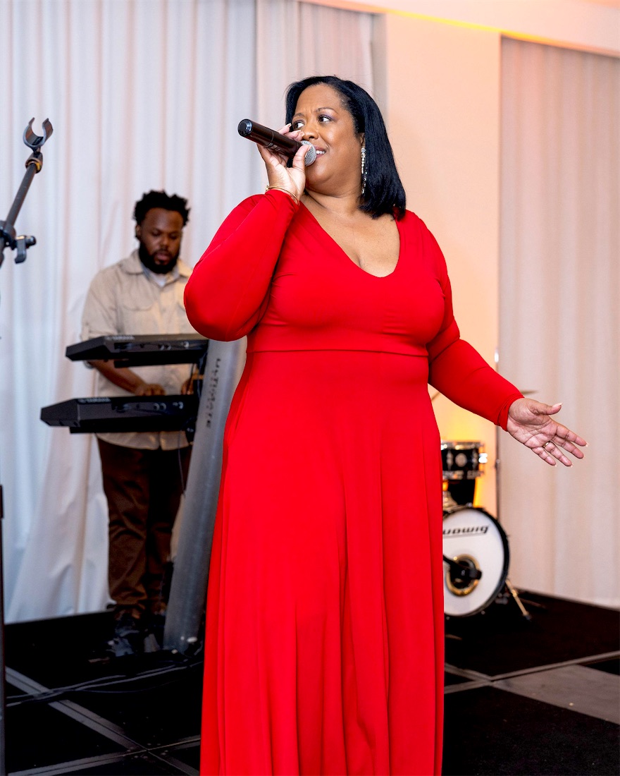 Queen B in red with the band