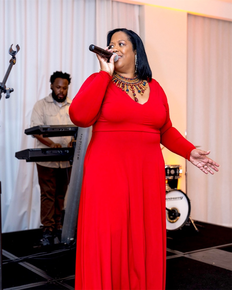 Queen B in red with the band