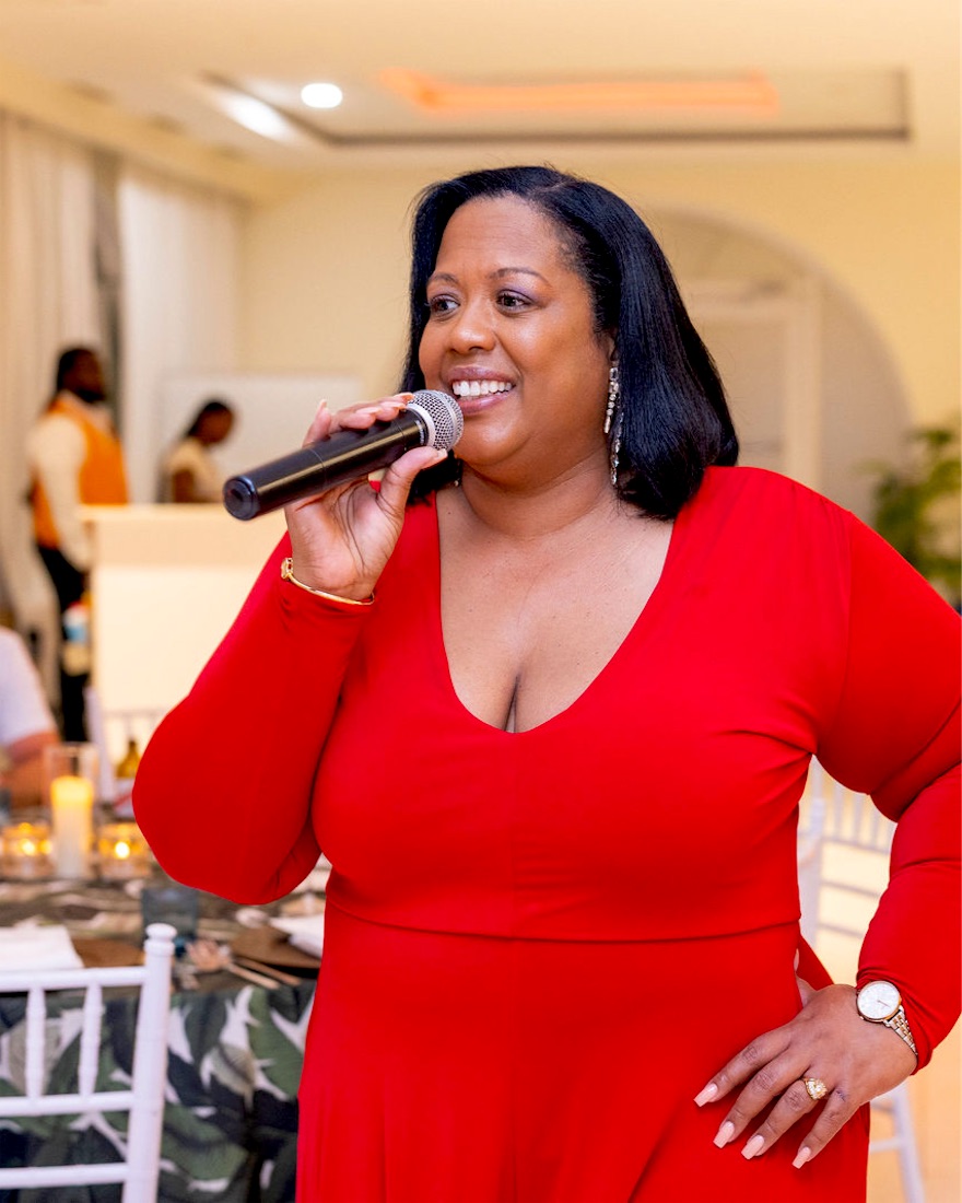 Queen B singing in red, hand on hip