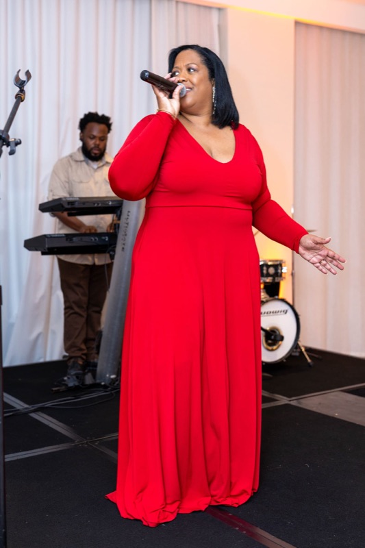 Queen B in a red gown on stage